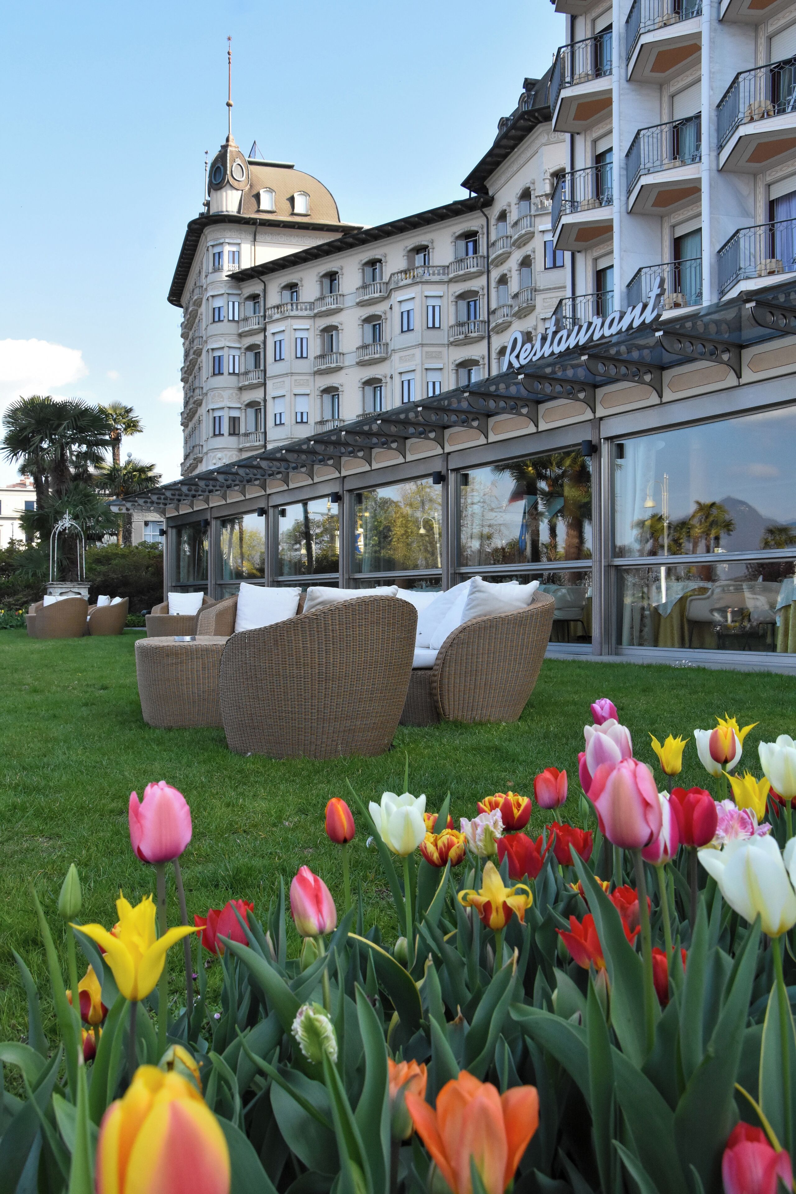 Un hotel con terraza exterior y un jardín de tulipanes.