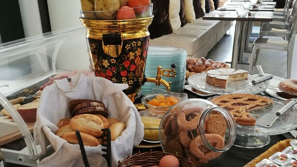 Een buffet met diverse soorten eten, waaronder gebak, fruit en sausjes.