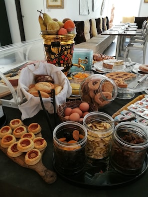 Una mesa de buffet con diversos alimentos, incluyendo pasteles, frutas y salsas.