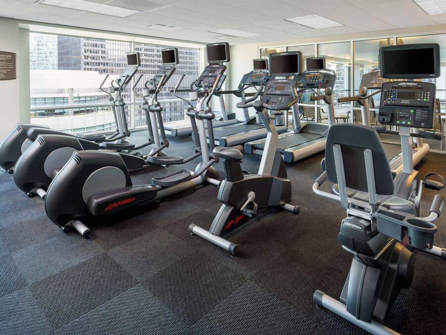 A gym with treadmills, elliptical machines, and weight machines.