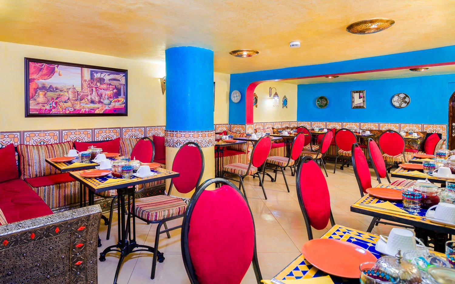A restaurant with colorful decor, including red chairs and patterned walls.