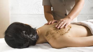 A person lying on a massage table receiving a back treatment.