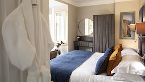 A hotel room with a bed, a mirror, a dresser, and a window. - Toravaig House Hotel (Sleat)