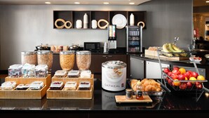 A breakfast buffet with various food items and a coffee machine.