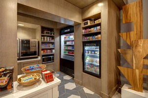 Uma cozinha compacta com geladeira, micro-ondas e freezer.