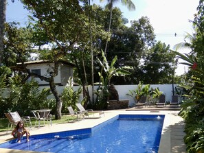 Una piscina al aire libre, sillones reclinables de piscina