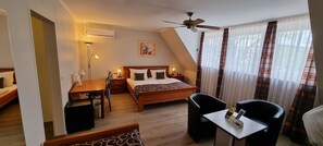 Relax in a stylishly designed room with a comfortable bed, desk, and large window offering a view of the outdoors.