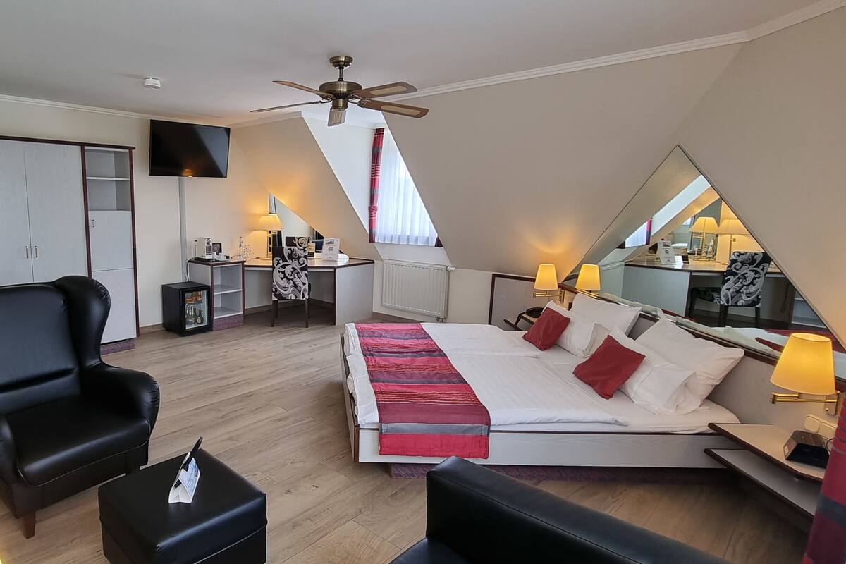 Une chambre à coucher comprenant un lit, un bureau, une chaise, une armoire et un téléviseur.