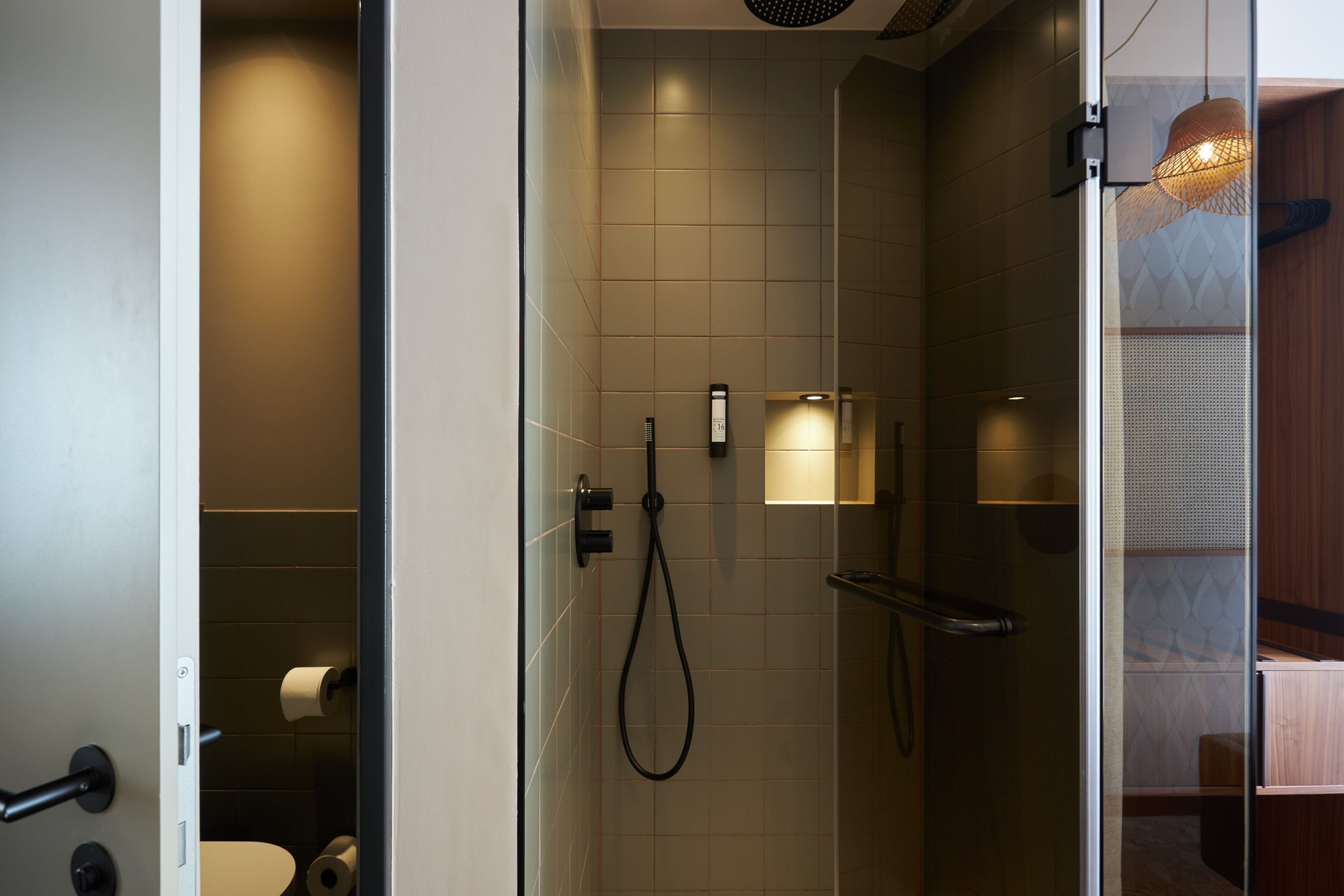 Ein modernes Badezimmer mit Duschkabine aus Glas, Toilette und Handtuchhalter.