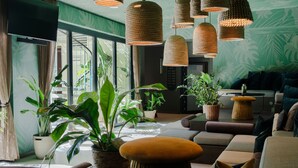 A modern lounge area with comfortable seating, large windows, and hanging woven light fixtures. - Cocoon München Sendlinger Tor (Munich)