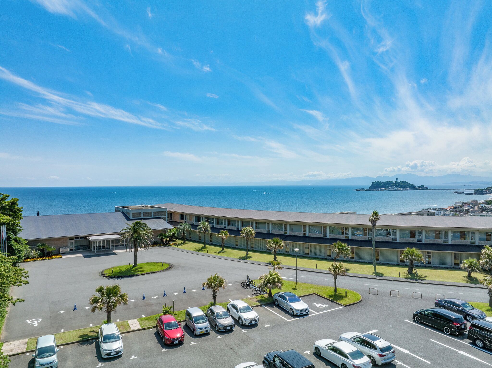 Un hotel con estacionamiento, vistas al mar y un edificio de techo plano.
