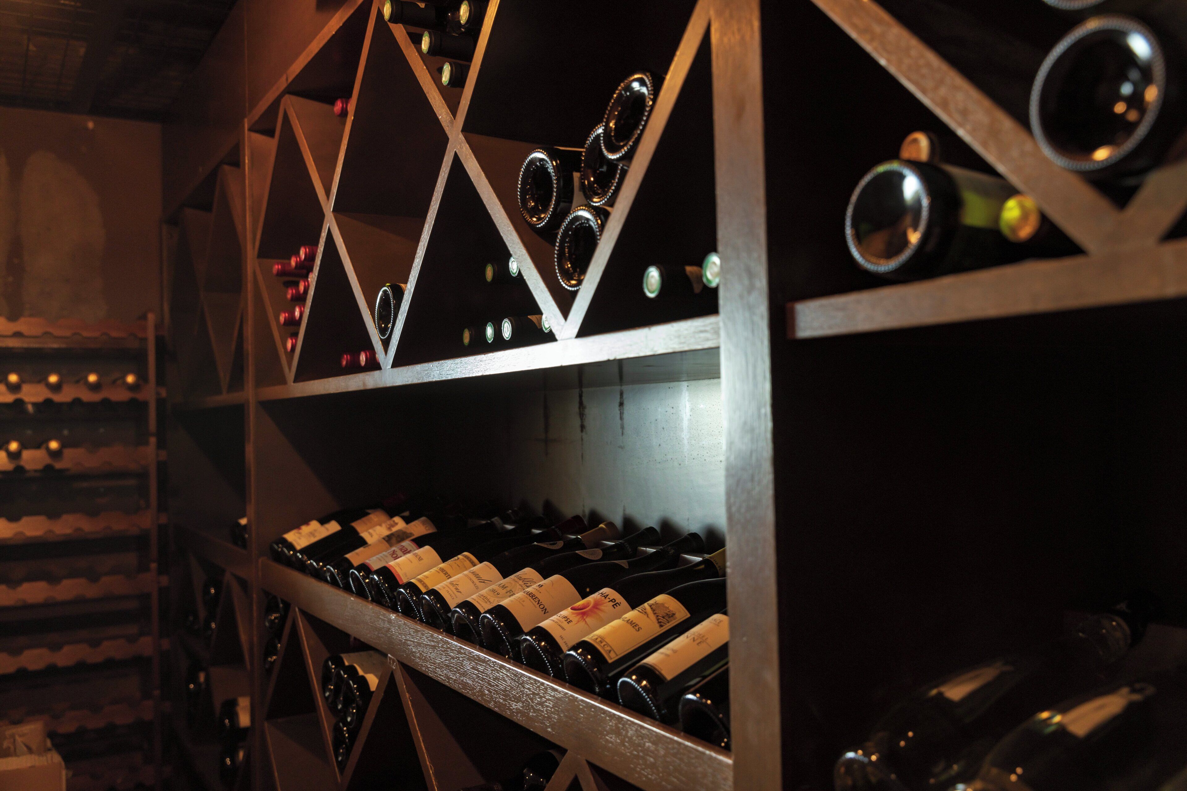 Une cave à vin dotée de plusieurs étagères et de nombreuses bouteilles.