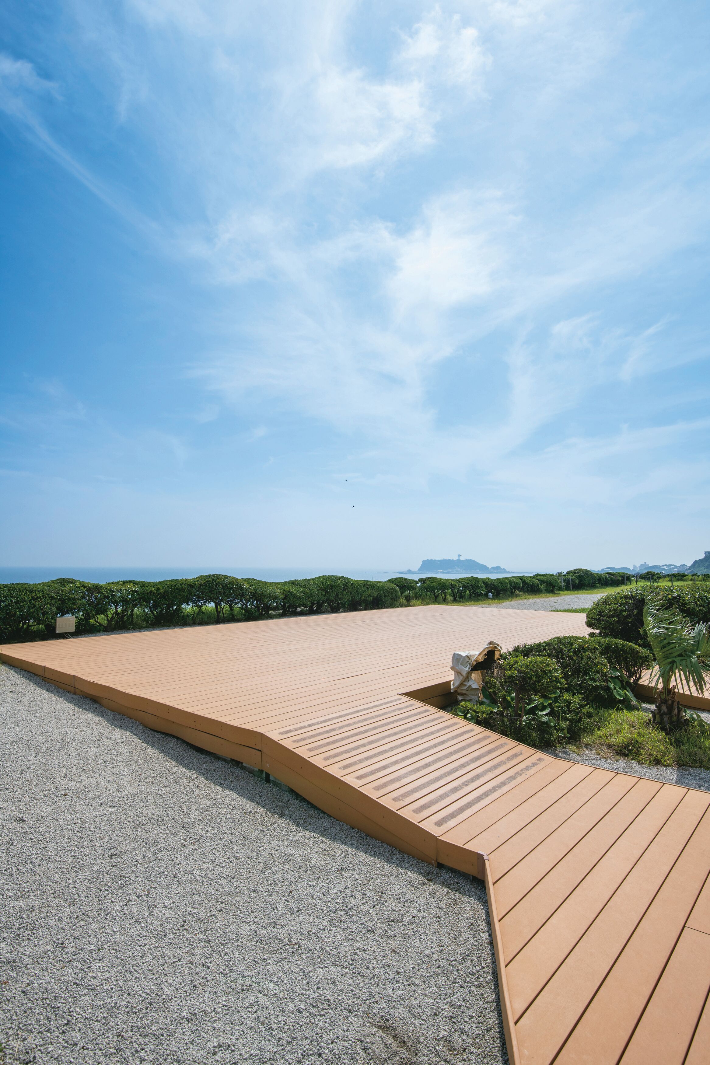 A spacious wooden deck with a clear view of the surrounding landscape and distant hills.