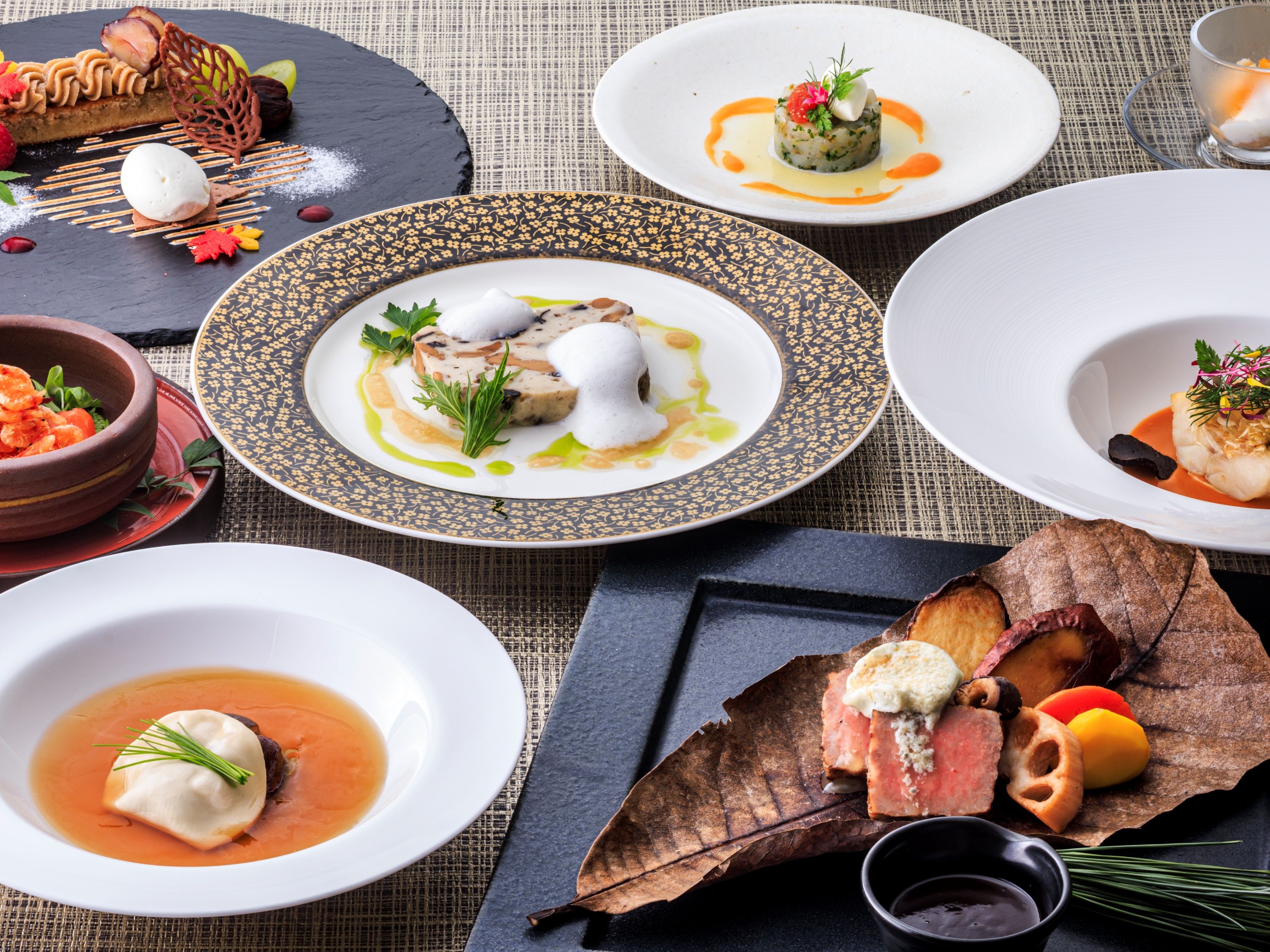 Variedad de platos en sus respectivos platos, sugiriendo una experiencia gastronómica de alta cocina.