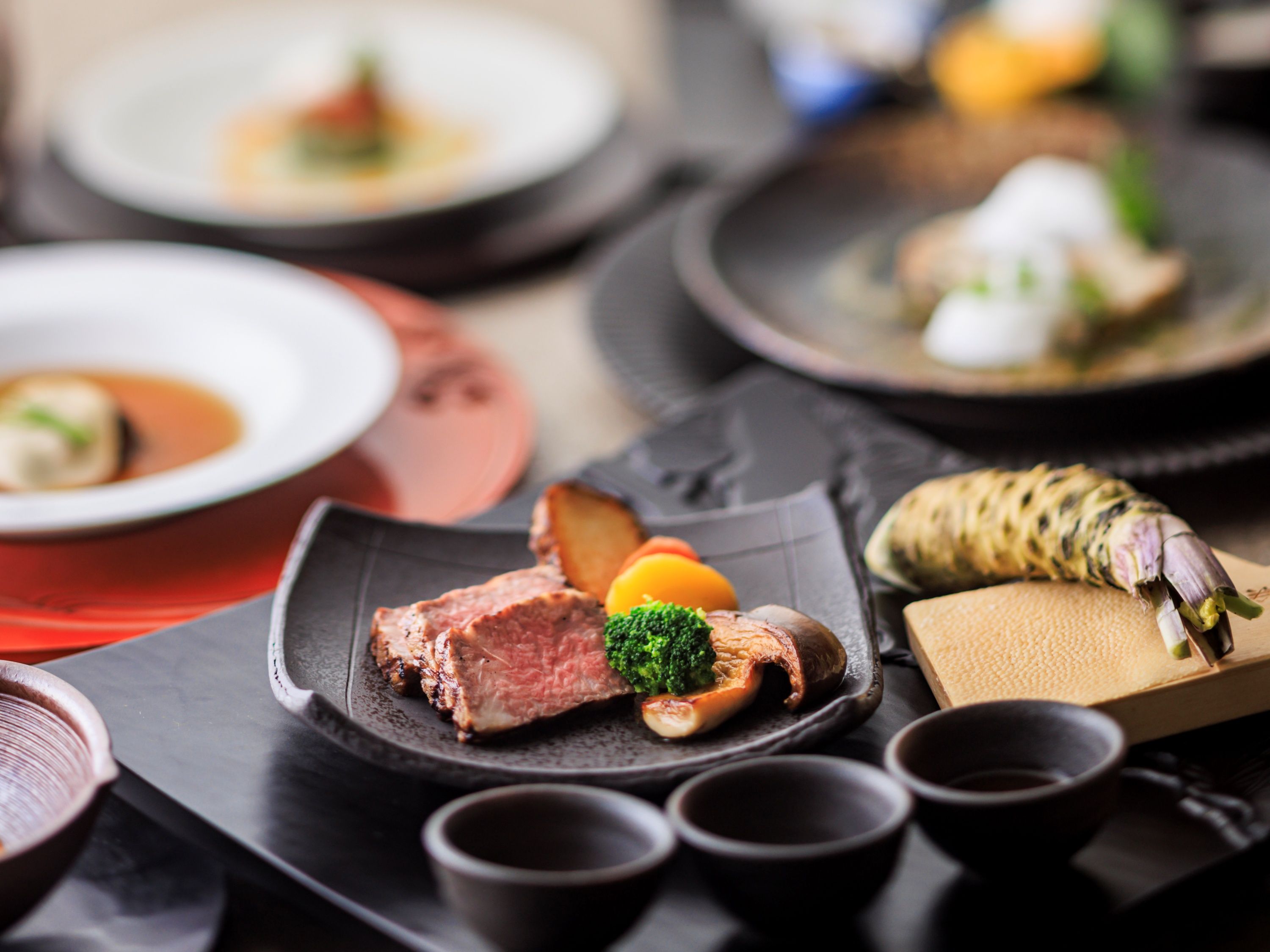 Una variedad de platos con carne, verduras y un pescado entero.