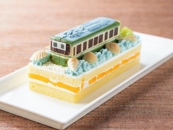 A dessert with a train-shaped cake on a white plate.