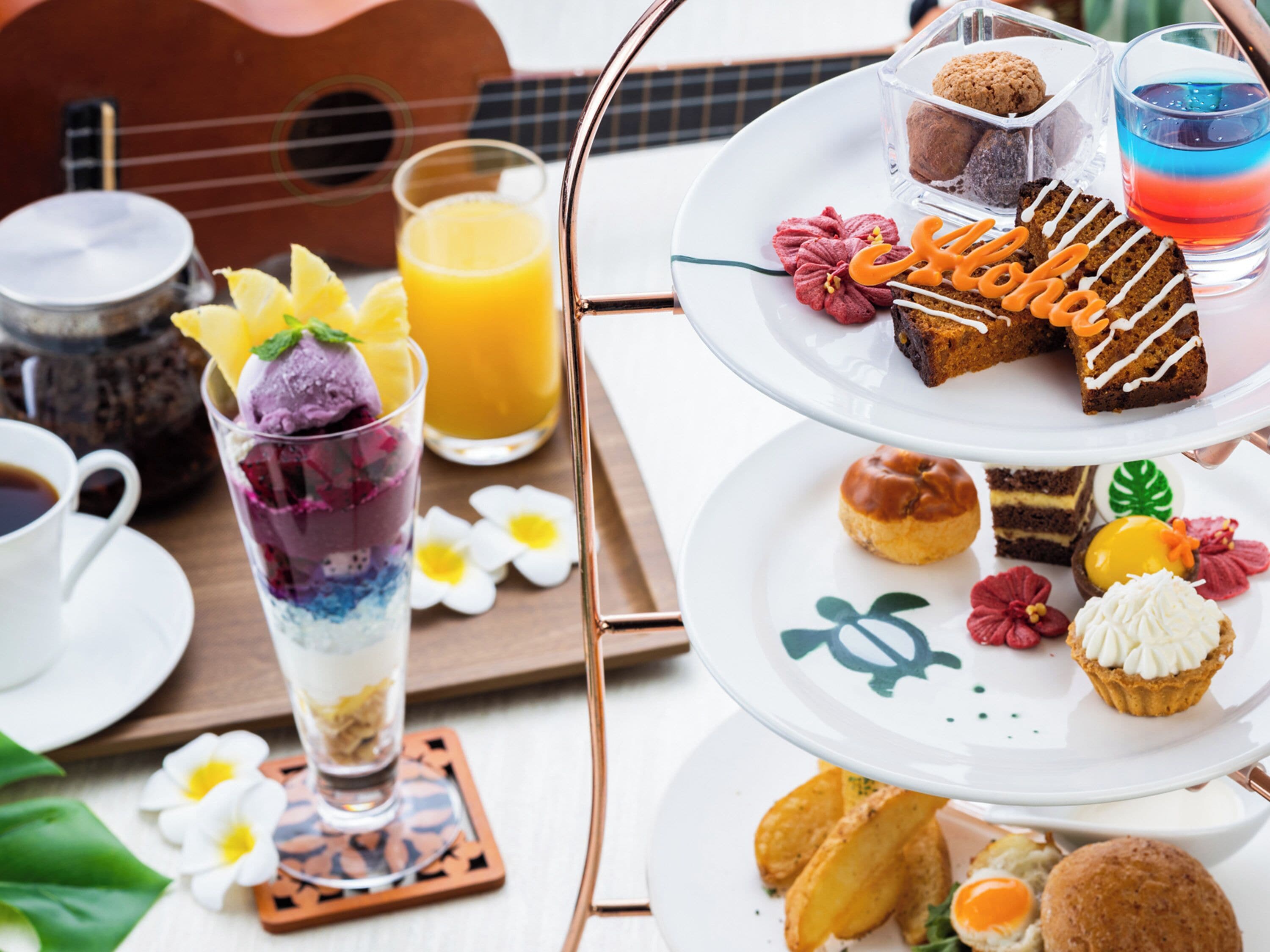 A tiered dessert tray with various pastries and a glass of orange juice.