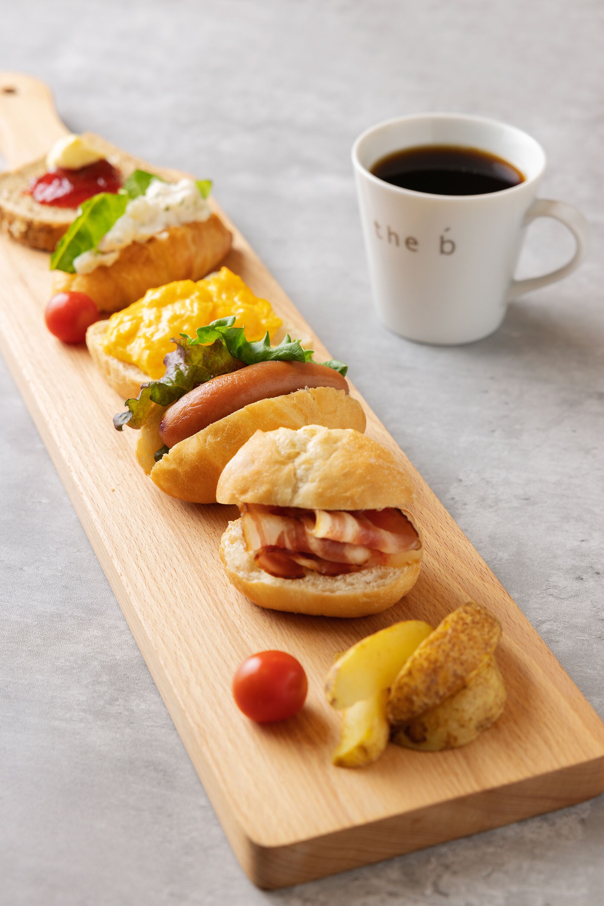 A wooden board with sandwiches and a cup of coffee.
