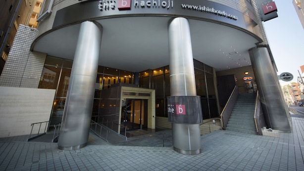 The exterior of the b hachijo hotel with a modern design, featuring a curved entrance and prominent pillars. - the b hachioji (Hachioji)
