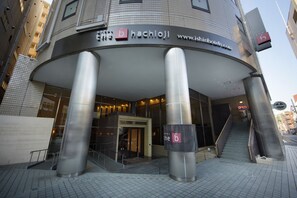 The exterior of the b hachijo hotel with a modern design, featuring a curved entrance and prominent pillars. - the b hachioji (Hachioji)