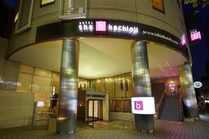 A hotel entrance with a prominent 'b' sign, a staircase, and a glass facade. - the b hachioji (Hachioji)