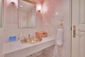 Une salle de bain équipée d’un lavabo, d’un miroir et d’un porte-serviettes.