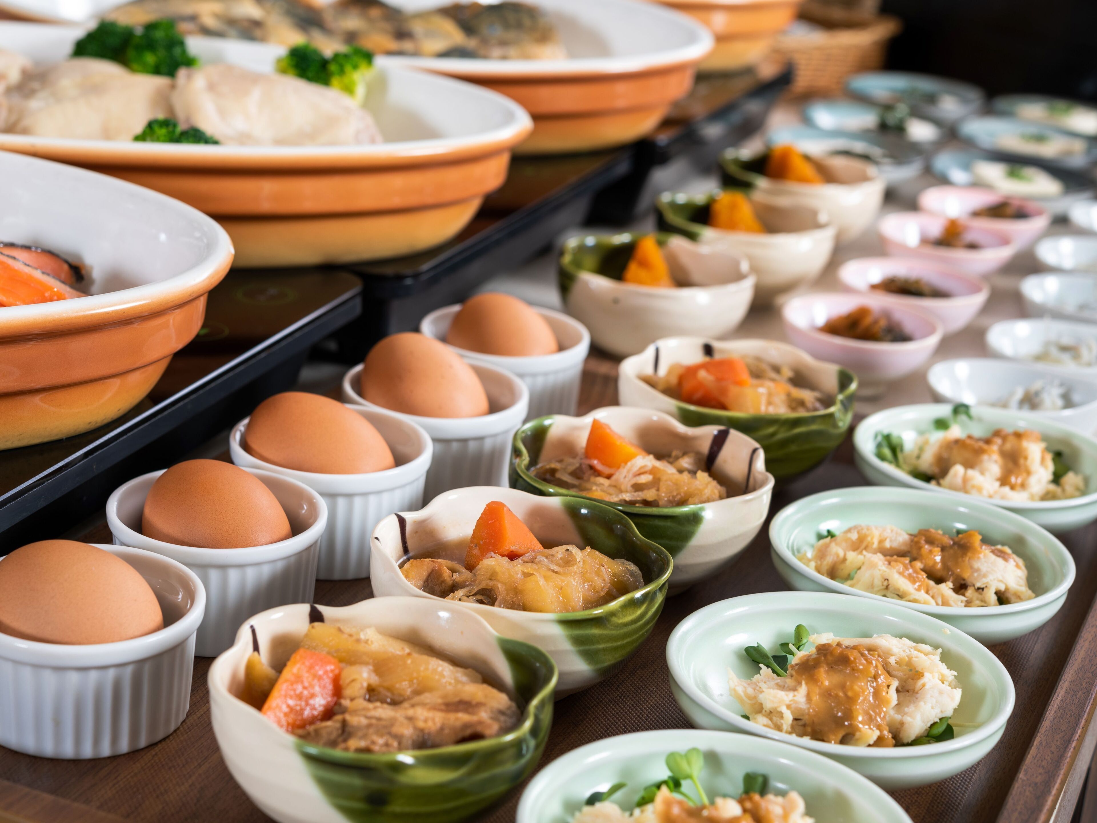Un buffet con diversi piatti, tra cui uova, verdure e carne.