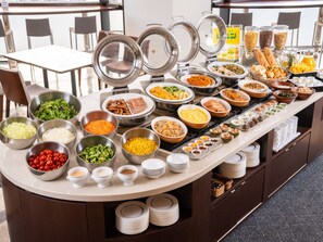 Una mesa de buffet con diversos alimentos y salsas.