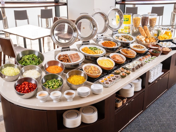 Una mesa de buffet con diversos alimentos y salsas.