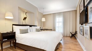 A hotel room with a large bed, bedside tables, a desk, and a chair.