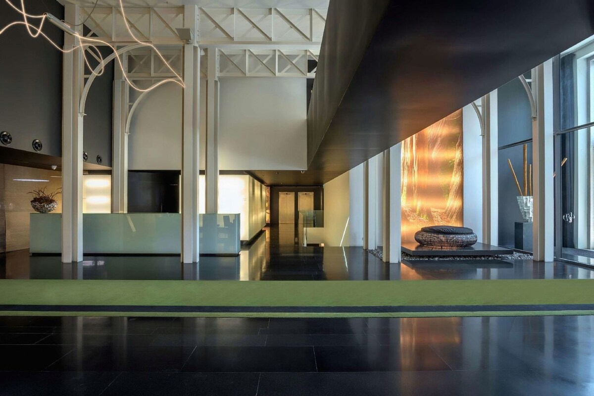 Eine großzügige Lobby mit einer Rezeption, einem Kamin und einem modernen architektonischen Design.