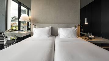 Una habitación de hotel moderna con una cama grande, un escritorio y una silla.