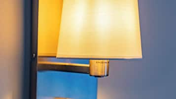 A wall-mounted lamp with a cylindrical shade and a metallic base.