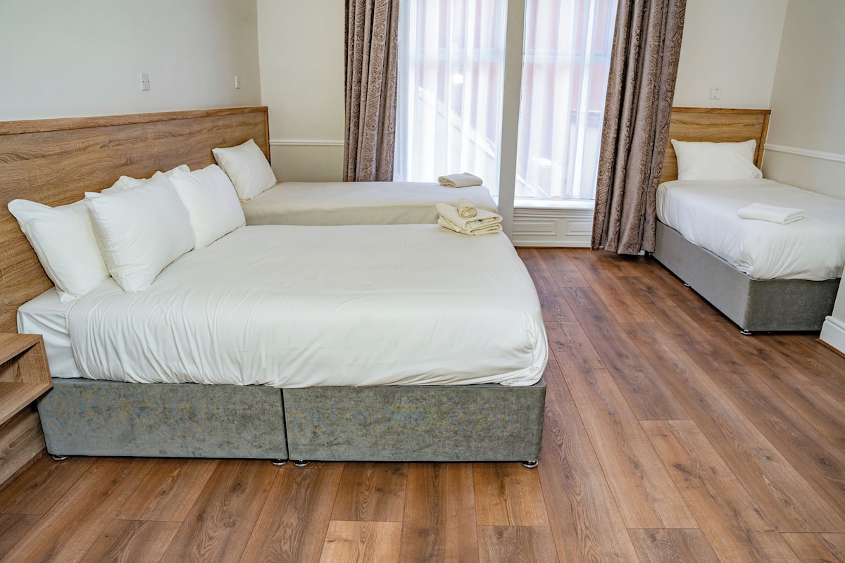 A bedroom with a large bed, a smaller bed, and a sofa bed.
