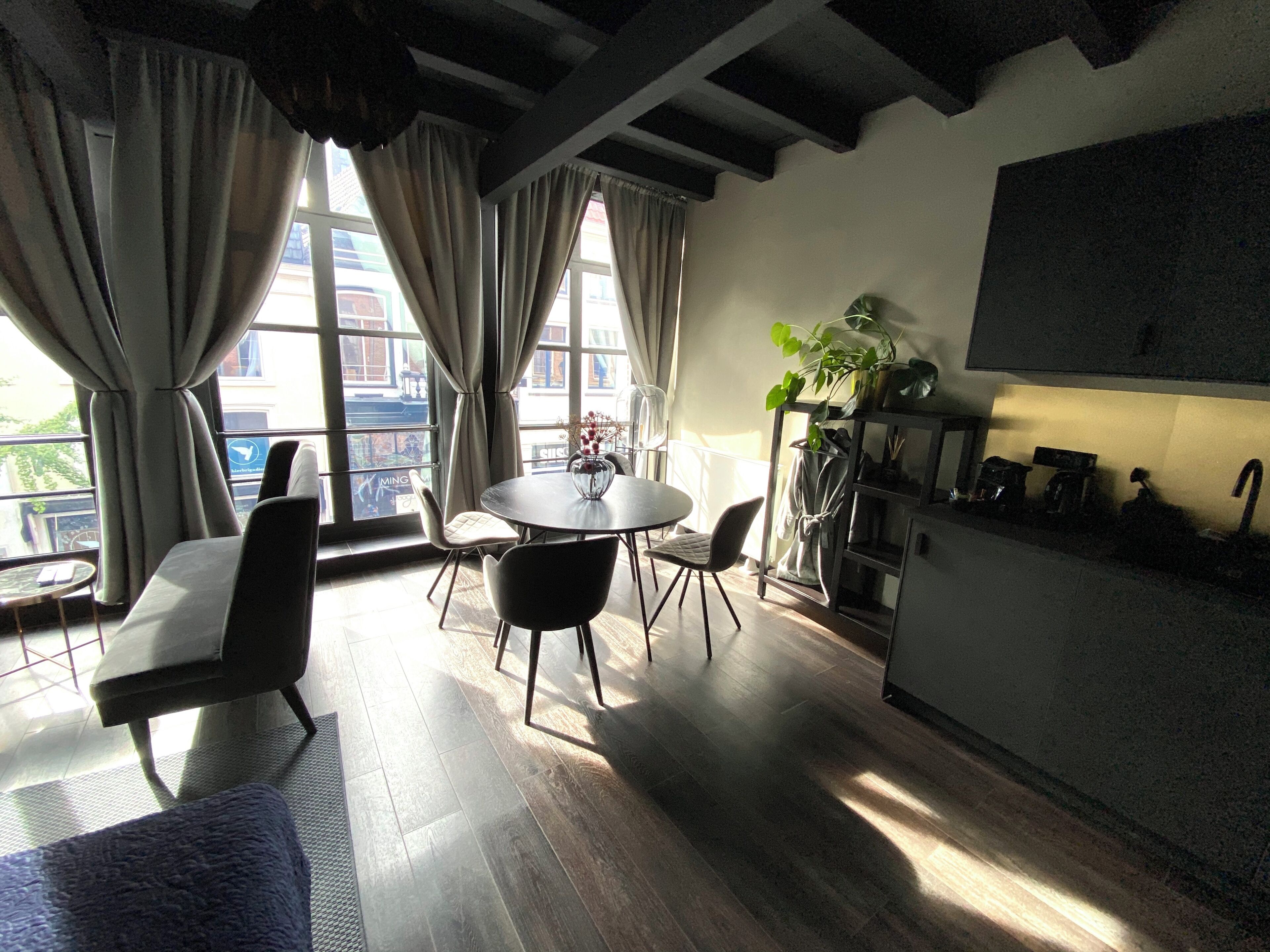Una cocina moderna con comedor, ventanas amplias y una planta.