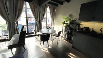 Una cocina moderna con comedor, ventanas amplias y una planta.