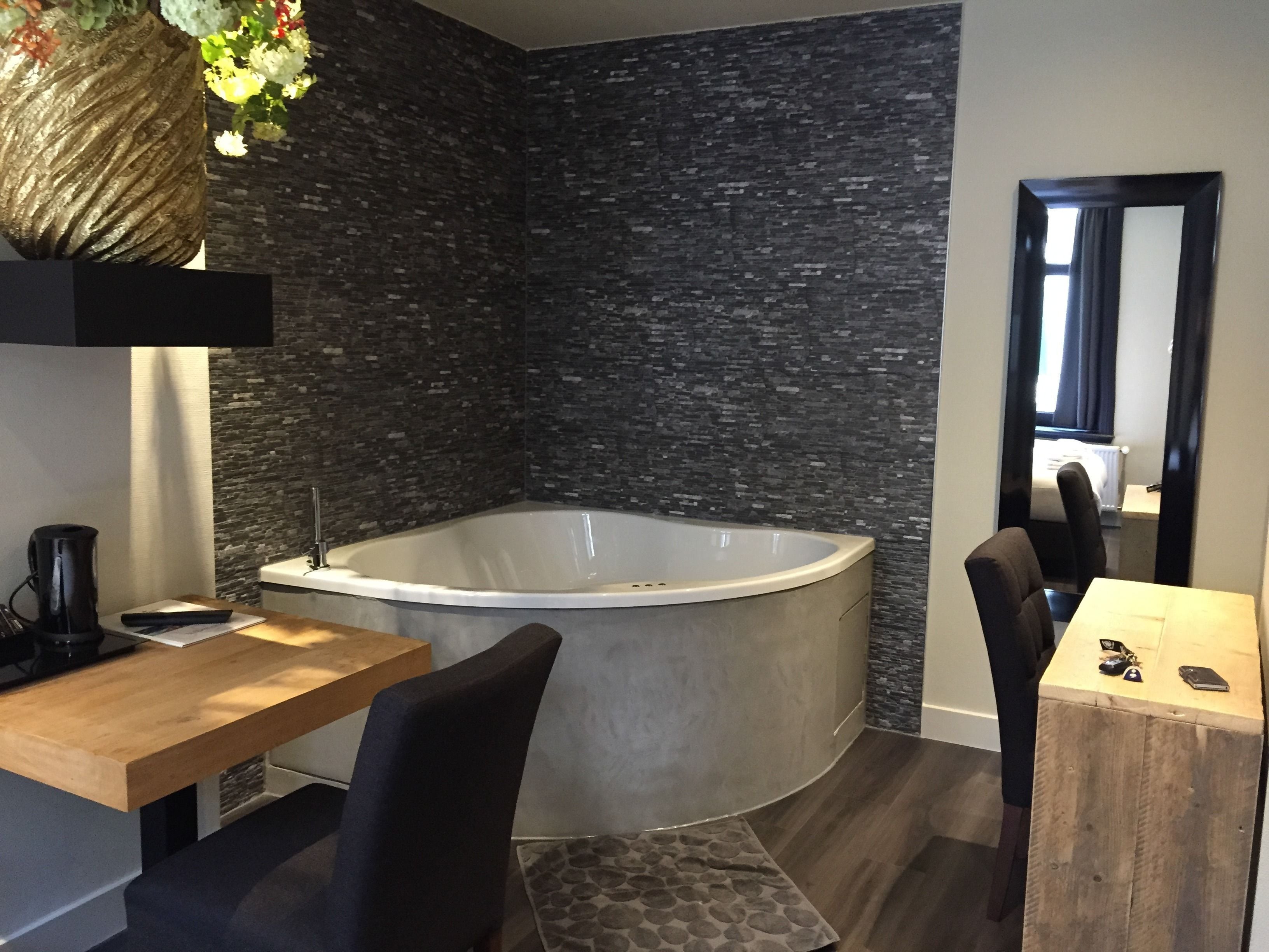 Une salle de bain moderne avec une baignoire sur pieds, un meuble-lavabo en bois et un miroir.