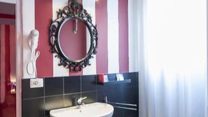 A bathroom with a large vanity sink, a small bidet, and a decorative mirror. - Il Giglio Rosso - B&B (Florence)
