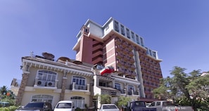 A multi-story building with balconies and a red awning. - Crown Regency Suites & Residences - Mactan (Lapu-Lapu)