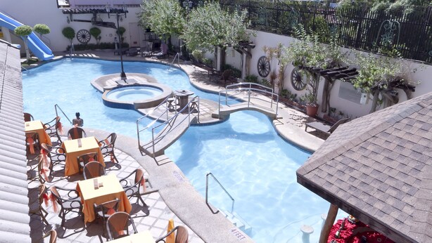 A pool area with multiple seating arrangements and a small water feature. - Crown Regency Suites & Residences - Mactan (Lapu-Lapu)