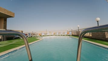 Outdoor pool, a rooftop pool, pool umbrellas, pool loungers