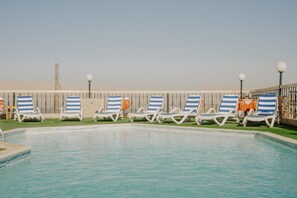 Outdoor pool, a rooftop pool, pool umbrellas, pool loungers