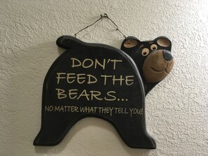 A wall-mounted bear-shaped decoration with a message.