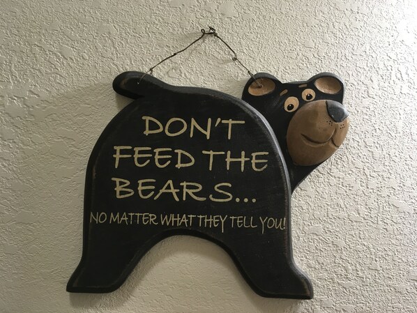 A wall-mounted bear-shaped decoration with a message.