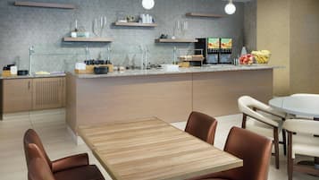 A modern kitchen with a central island, built-in appliances, and a dining area with leather chairs.