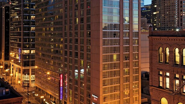 A high-rise hotel with a modern glass facade, multiple floors, and a prominent corner entrance. - Residence Inn by Marriott Chicago Downtown / River North (Chicago)