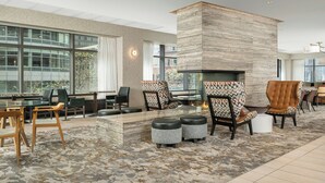A modern lobby with a fireplace, seating area, and large windows. - Residence Inn by Marriott Chicago Downtown / River North (Chicago)