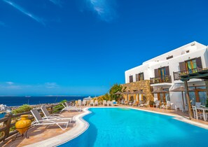 Una piscina al aire libre, sombrillas, tumbonas