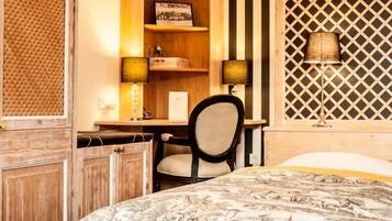 A bedroom with a bed, a desk, a chair, and a wall with a lattice design.