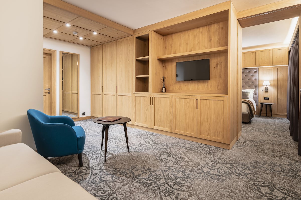 Una sala de estar moderna con un sofá, un sillón azul, una mesita y armarios empotrados de madera.